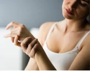 Young woman holding left wrist like she is in pain