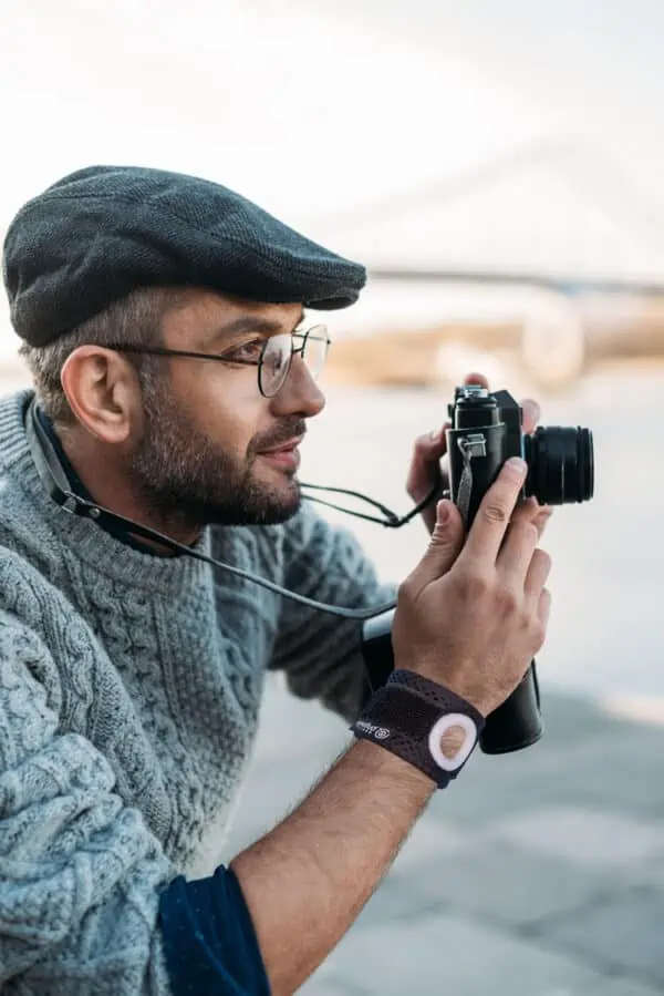 man wearing Bullseye Brace wrist band and holding a camera