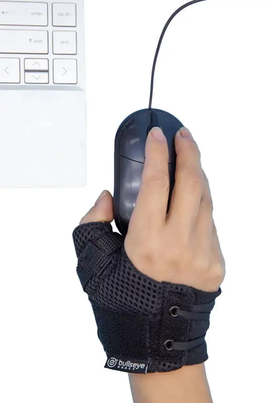 Bullseye Brace Thumb Brace on hand while using a mouse. Wearing the CMC brace helps with overuse injuries like those who use a computer mouse for long period of time.