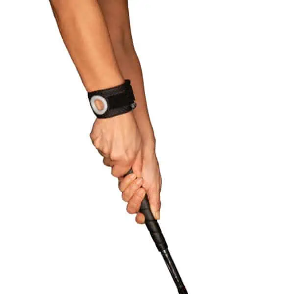 Hands gripping golf club with Bullseye Brace Wrist Band worn on right wrist